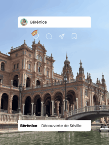 Façade majestueuse de la Plaza de España à Séville avec ses briques rouges, ses arcades et ses tours, photographiée depuis un canal sous un ciel bleu.