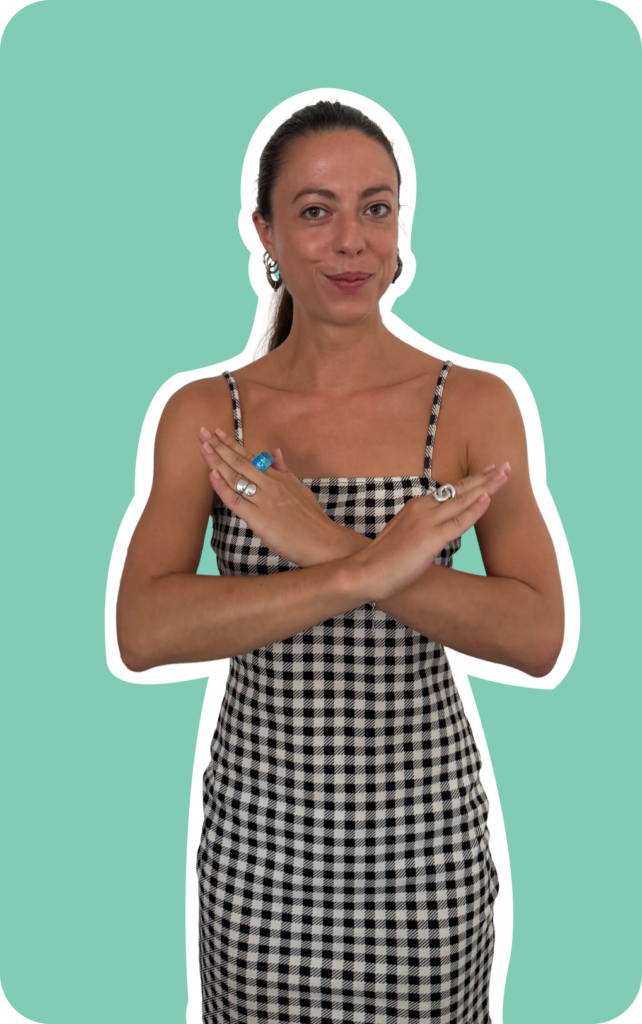Jeune femme aux cheveux attachés, en robe à motif vichy noir et blanc à fines bretelles, faisant un signe de croix avec ses avant-bras devant sa poitrine (geste de refus ou d'interdiction), regard direct et sourire en coin. Photo détourée façon sticker avec contour blanc, sur fond vert menthe.